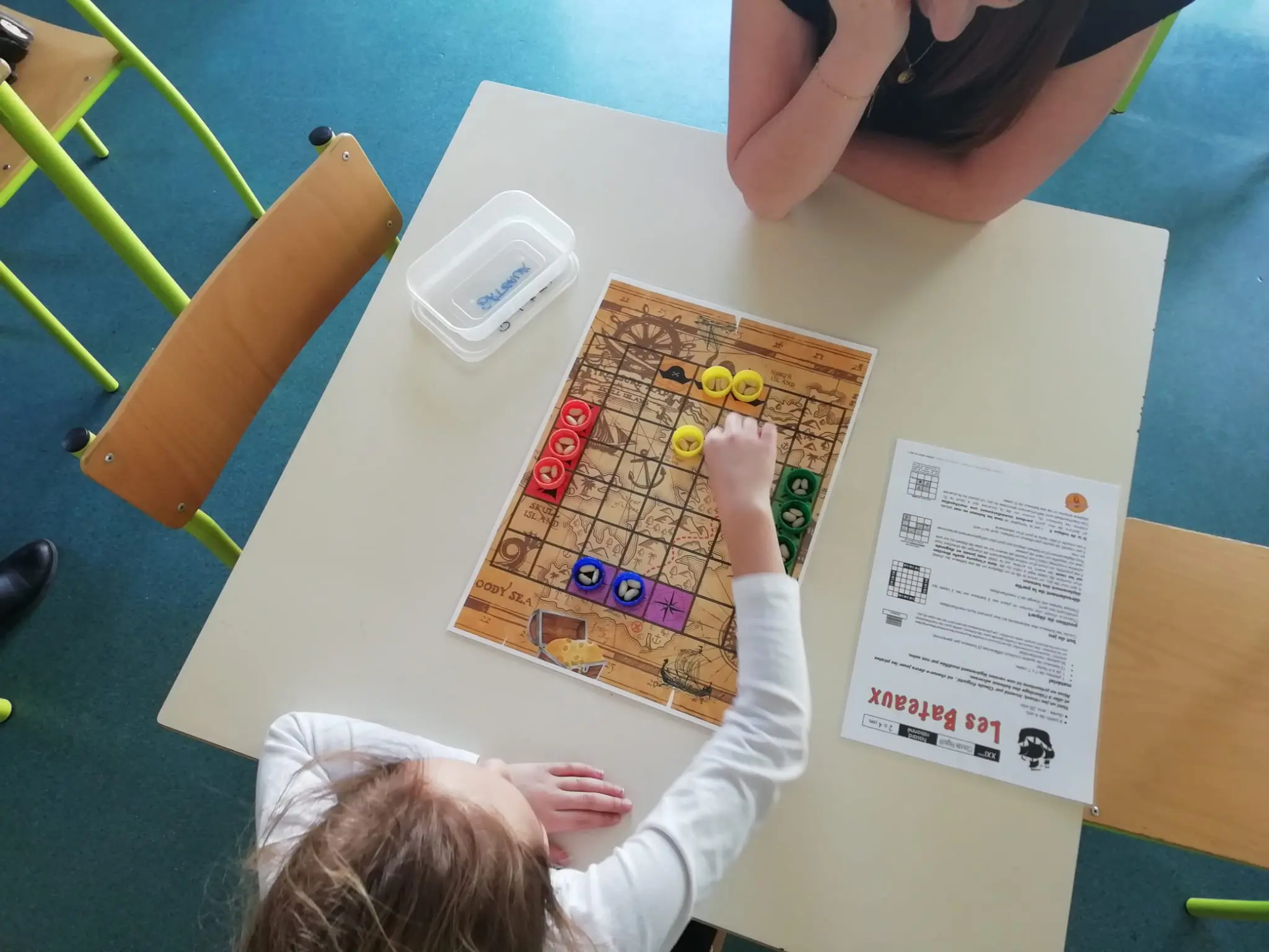 Groupe d'enfants autour d'un jeu de société fait maison en centre de loisirs